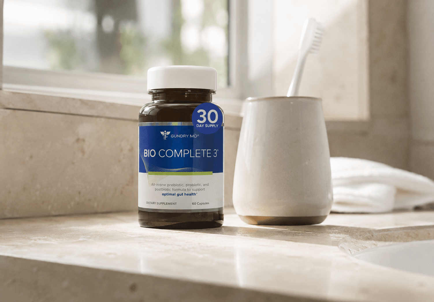 Woman holding Bio Complete 3 bottle on bathroom counter, everyday lifestyle shot