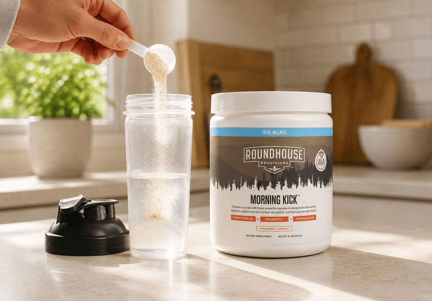 Scooping Morning Kick powder into a shaker bottle in a home kitchen