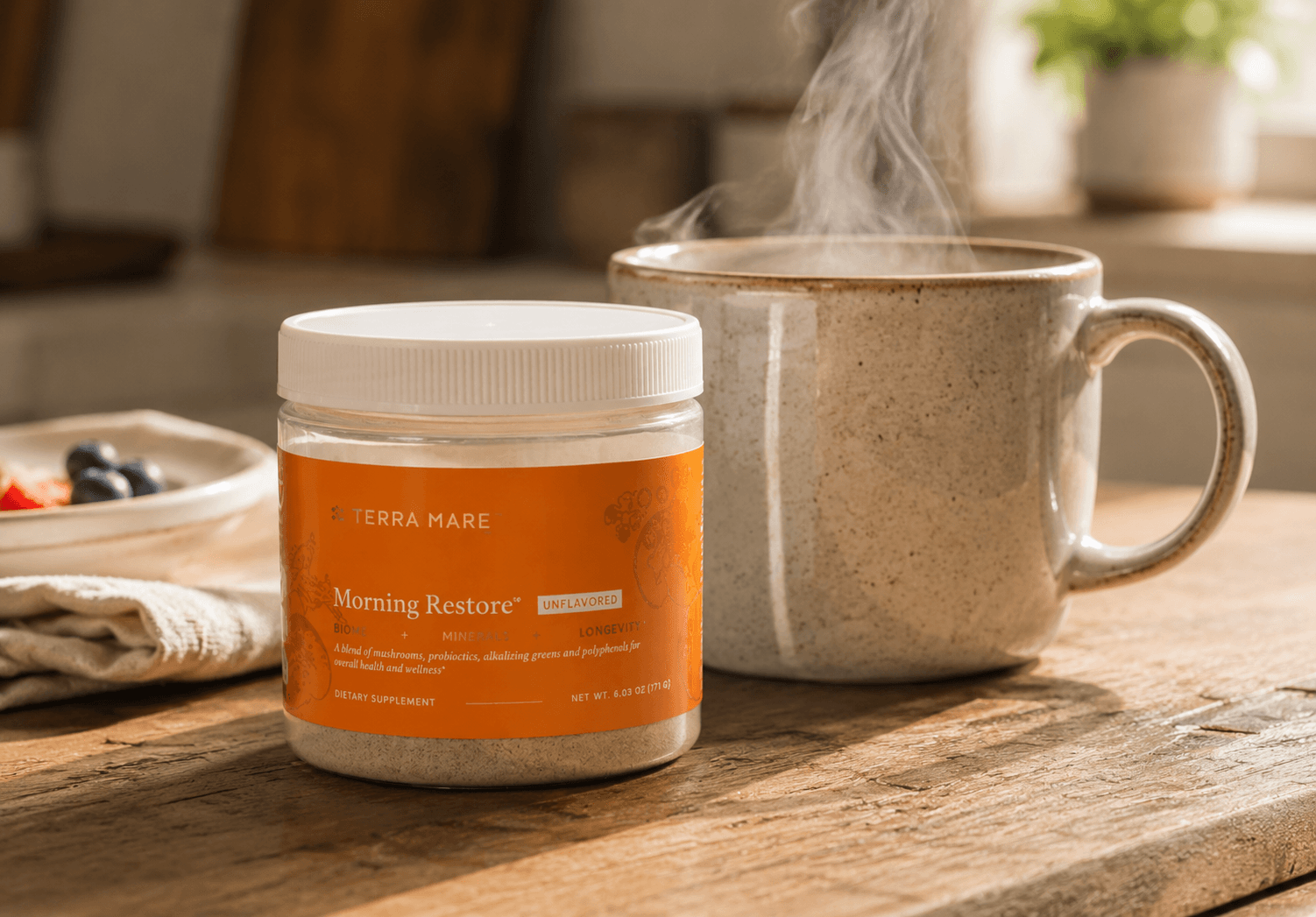 Morning Restore jar by Terra Mare next to a steaming mug on a wood table