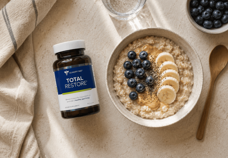 Total Restore bottle beside a bowl of oatmeal with berries, flat lay