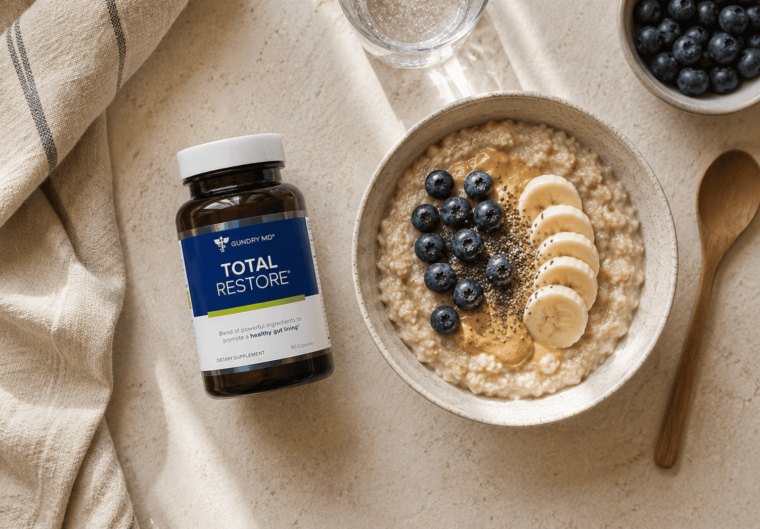 Total Restore bottle beside a bowl of oatmeal with berries, flat lay