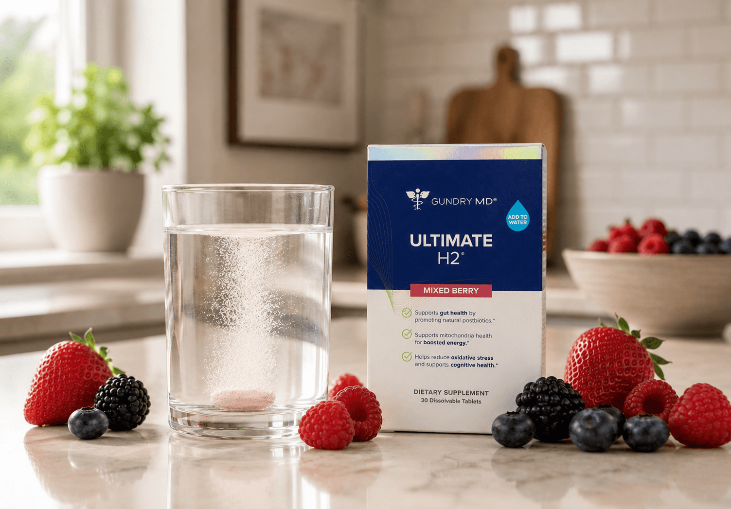 Ultimate H2 mixed berry box beside a glass of water and fresh berries