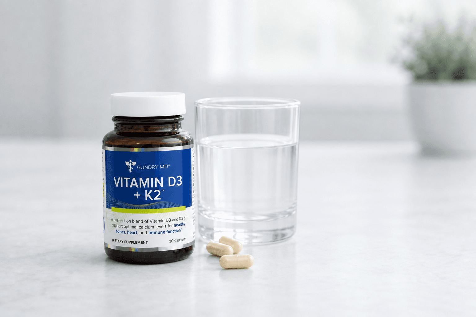 Bottle of Gundry MD Vitamin D3 and K2 with water glass on kitchen counter